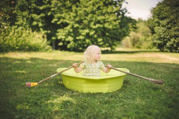 Long Life Childhood girl in a boat with oars