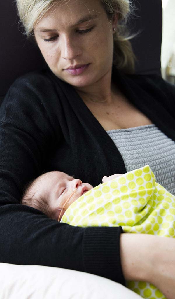 Mom looking down at infant she is holding.