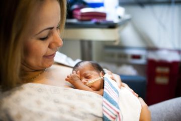 Mom holding infant in the NICU