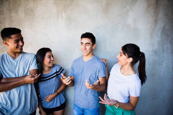 Teen boys and girls talking and laughing together