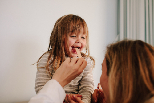 Clinician is checking child's tonsils