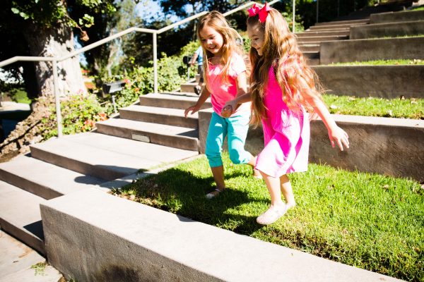 Girls holding hands playing on the grass