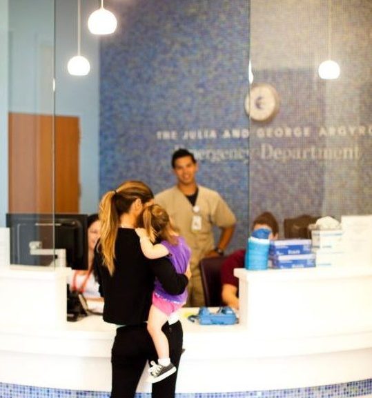 mom carrying daughter to emergency department