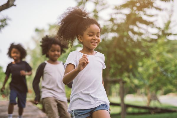 young girl running in the park with friends