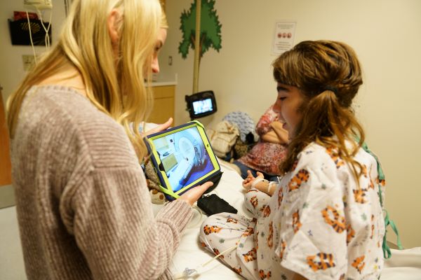 child life specialist showing mri machine to young patinet