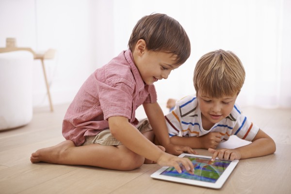 two young boys playing ganmes on a tablet