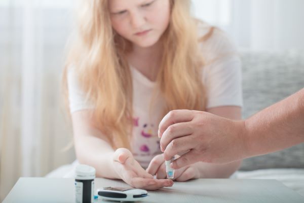 young diabetic girl checking blood sugar levels