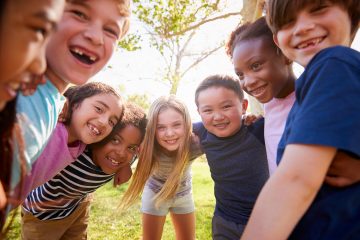 Group of kids outside in a circle smiling