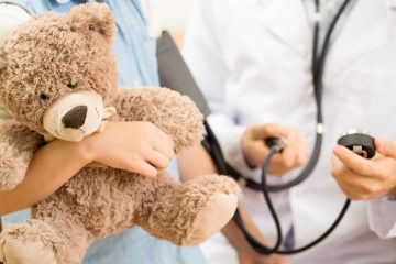 Clinician with patient holding a bear