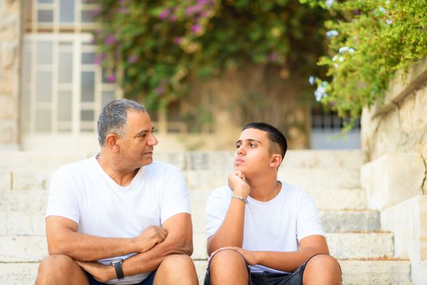 teenager with PTSD talking with father on steps