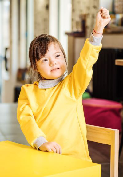 young girl raising hand at school