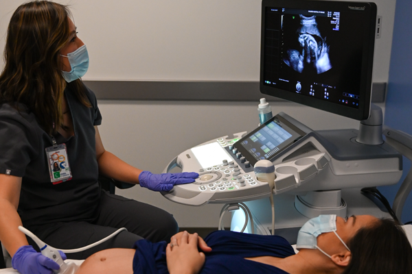 technician performing ultrasound on pregnant woman
