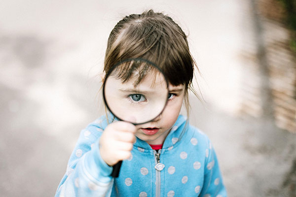 kid looking through magnifying glass