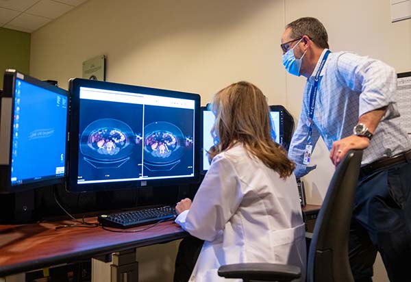 Pediatric radiologists reviewing scans on monitors