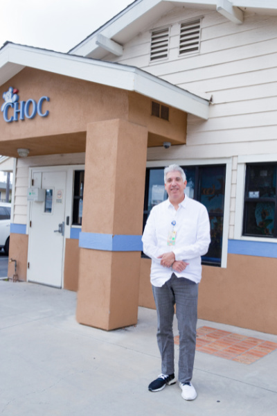 Male pediatrician stands outside the clinic