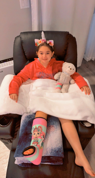 patient with decorated cast and teddy bear