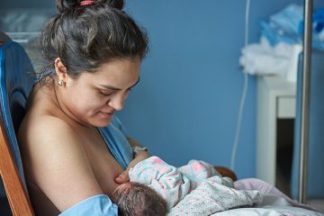 Woman breastfeeds baby in hospital
