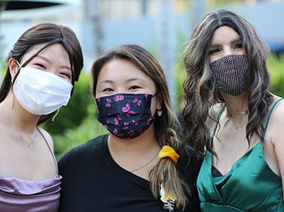 Three girls wearing dresses and face masks at the CHOC Oncology Ball
